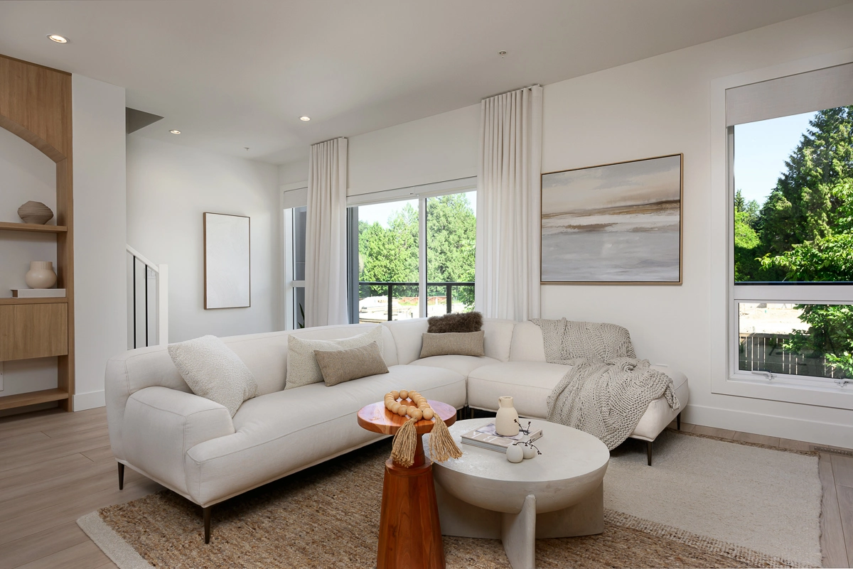 Plan A – primary living room with sectional, large windows and forest view