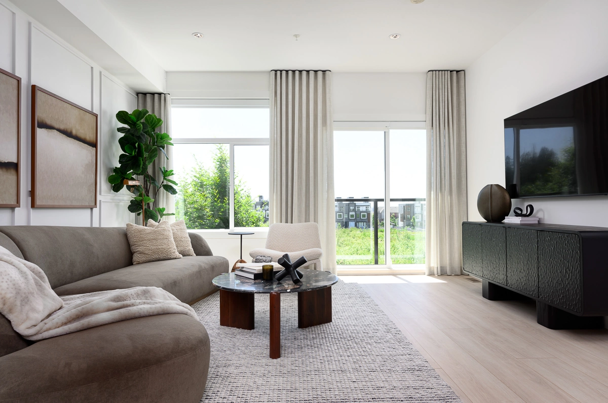 Plan B – main living room with sectional, mounted television and floor-to-ceiling drapery framing the balcony