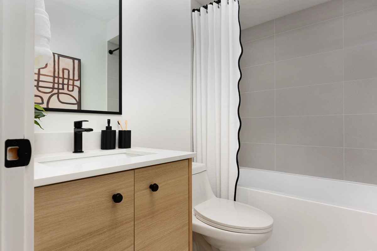 Plan B – main bathroom with oak vanity, black fixtures, soaker tub and waved shower curtain