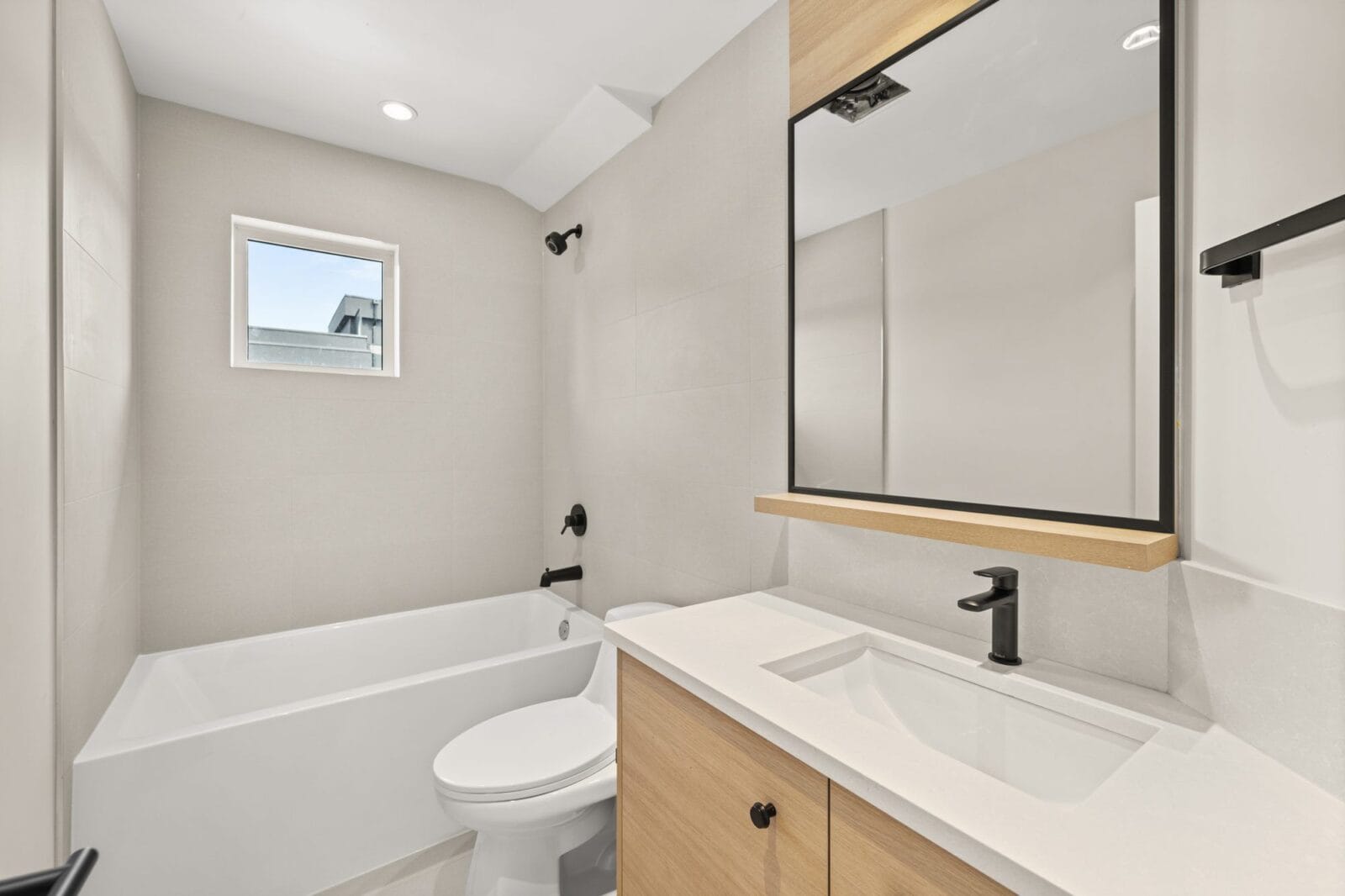 Ensuite detail with mirrored medicine cabinets, quartz counter and black designer fixtures