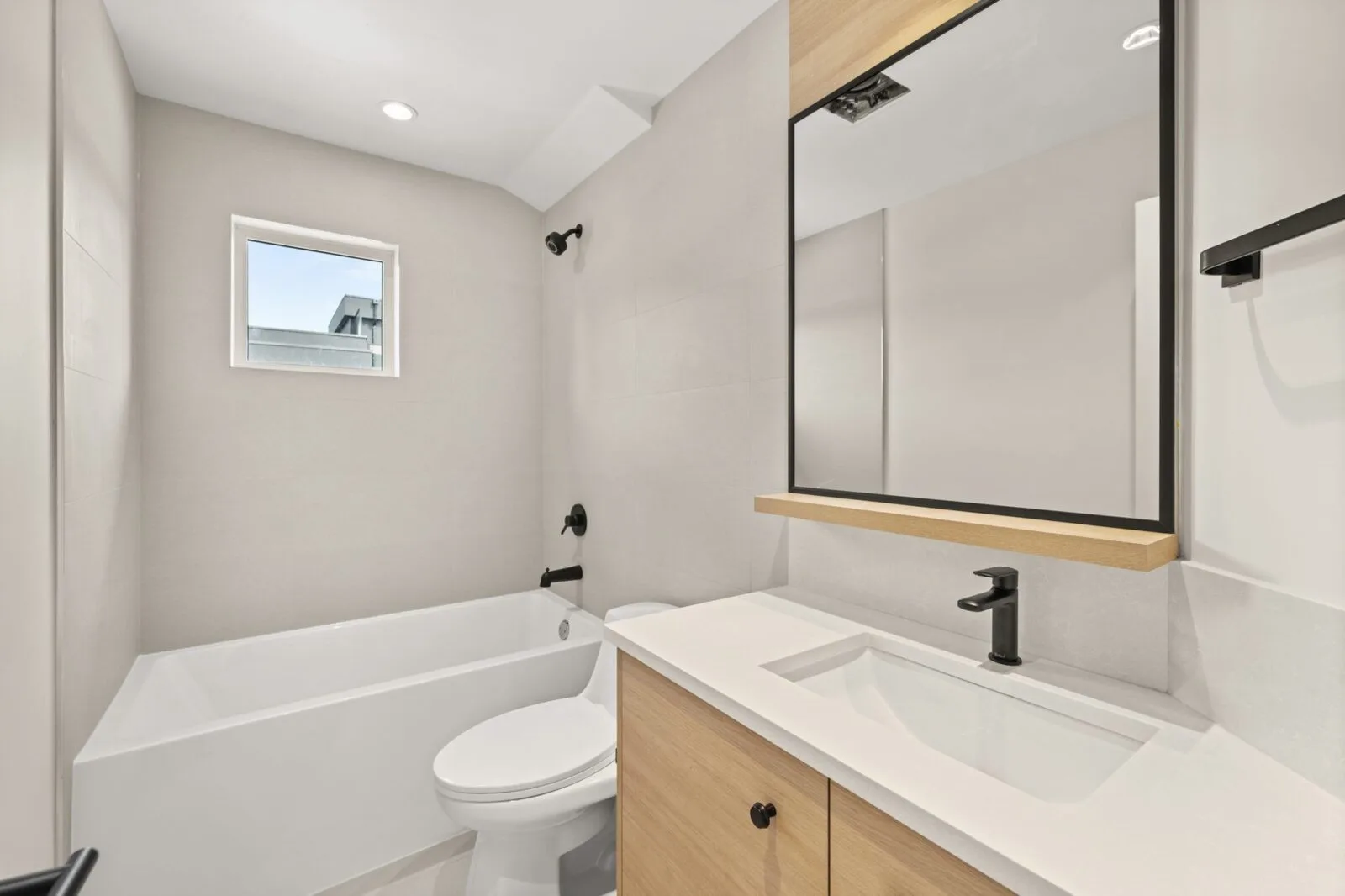 Ensuite detail with mirrored medicine cabinets, quartz counter and black designer fixtures